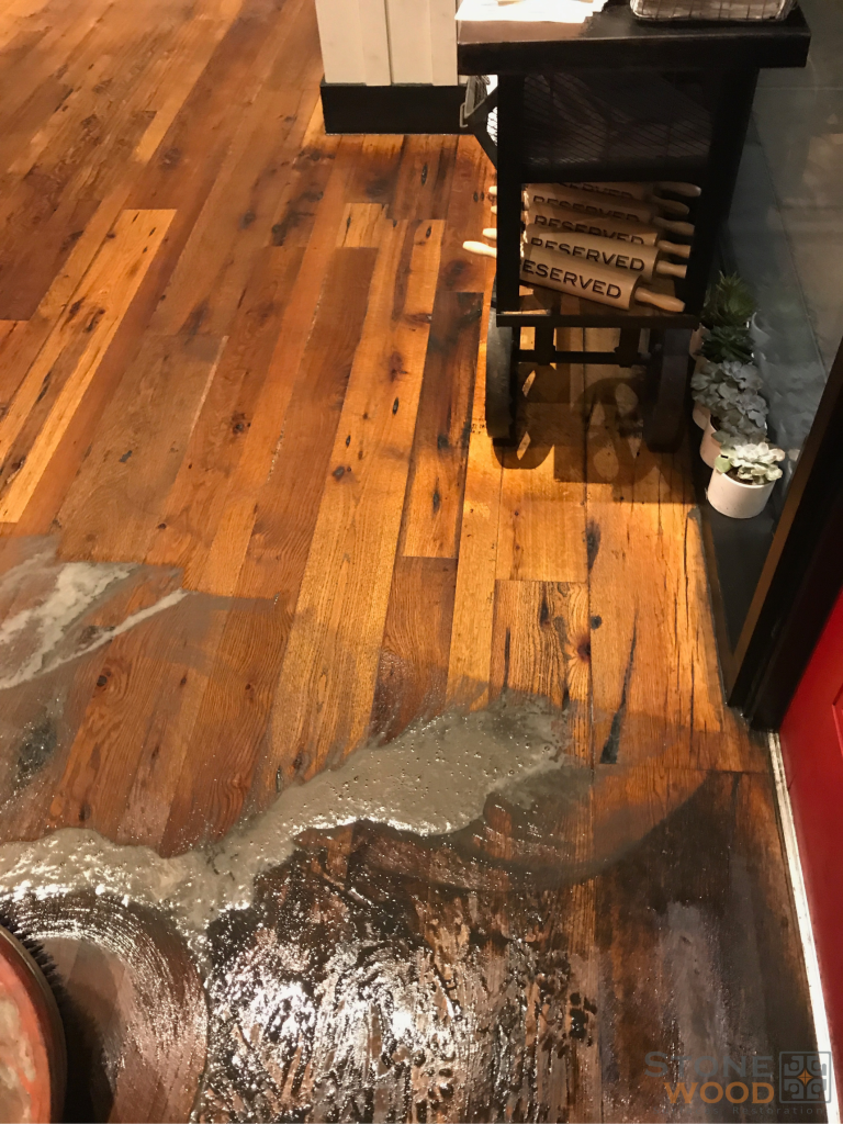 Worn hardwood floor with water damage, dull finish, and surface deterioration requiring professional restoration in Houston TX